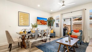 A modern living room with a dining area, featuring a dining table, chairs, a sofa, and a coffee table. - Freedom Village 549, Smart TV, Private Balcony, Resort Amenities and more (Washington)