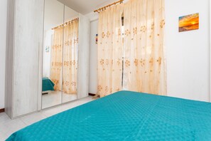 Een slaapkamer met een bed, een kledingkast en een spiegel.