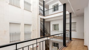 Un intérieur à plusieurs niveaux, avec un escalier, des rampes et un revêtement de sol carrelé.