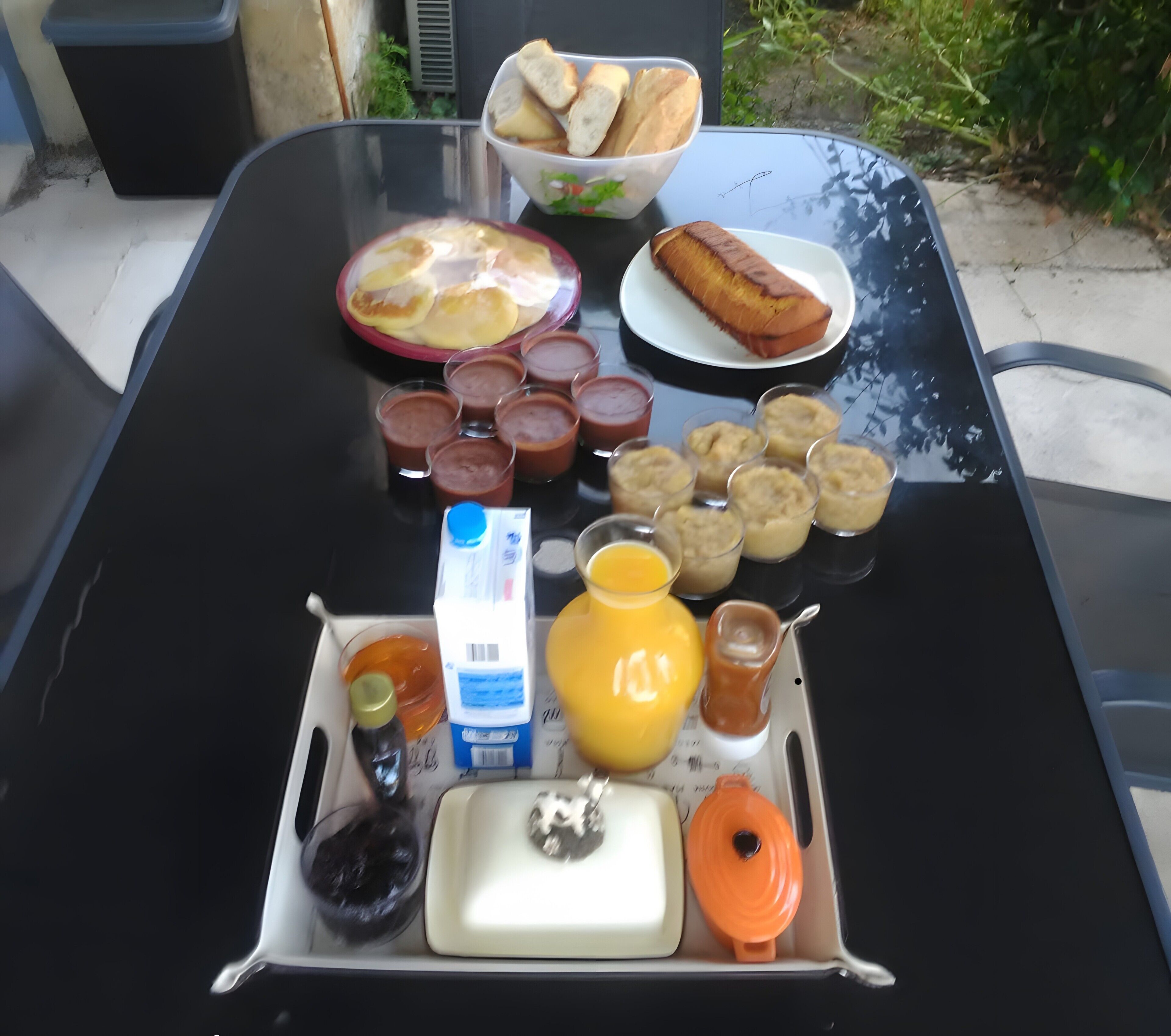 Una mesa con alimentos para el desayuno, incluyendo pan, huevos y diferentes salsas.