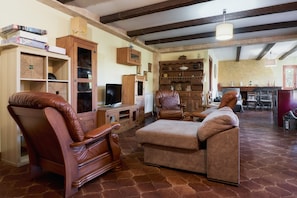 A living room with a fireplace, leather chairs, a television, and wooden cabinets. - Country House 'Arroyo Del Valle' with Terrace and Private Garden (San Andrés del Rabanedo)