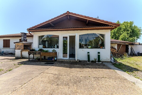 A single-story house with a tiled roof, a front porch, and a small garden area. - My Pied-à-Terre Near the Ocean (Saint-Julien-en-Born)