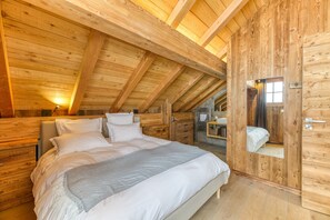 A wooden cabin bedroom with a bed, a nightstand, and a mirror.