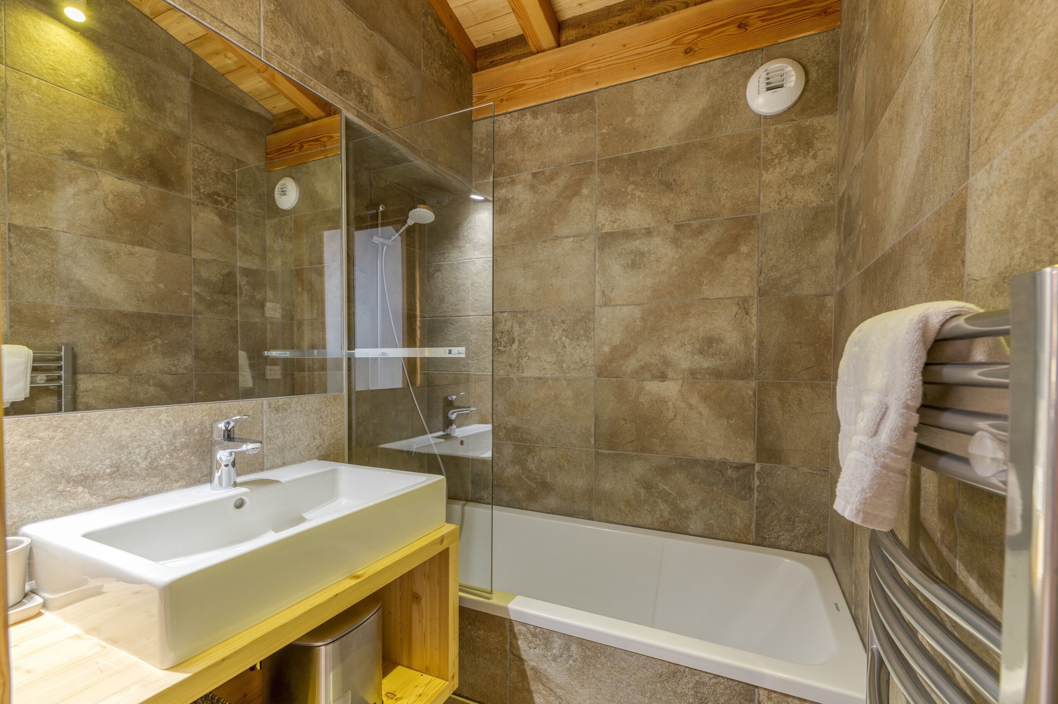 Une salle de bain équipée d’un lavabo, d’un miroir, d’une douche et d’une baignoire.