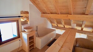 A wooden interior with a bathtub, a window, and a sink. - Chalet '4 Étoiles La Saulire' with Mountain View, Shared Terrace and Wi-Fi (Villard-Reculas)
