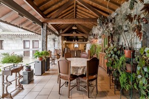Un coin repas au style rustique, avec une table ronde, des chaises et des plantes en pot.
