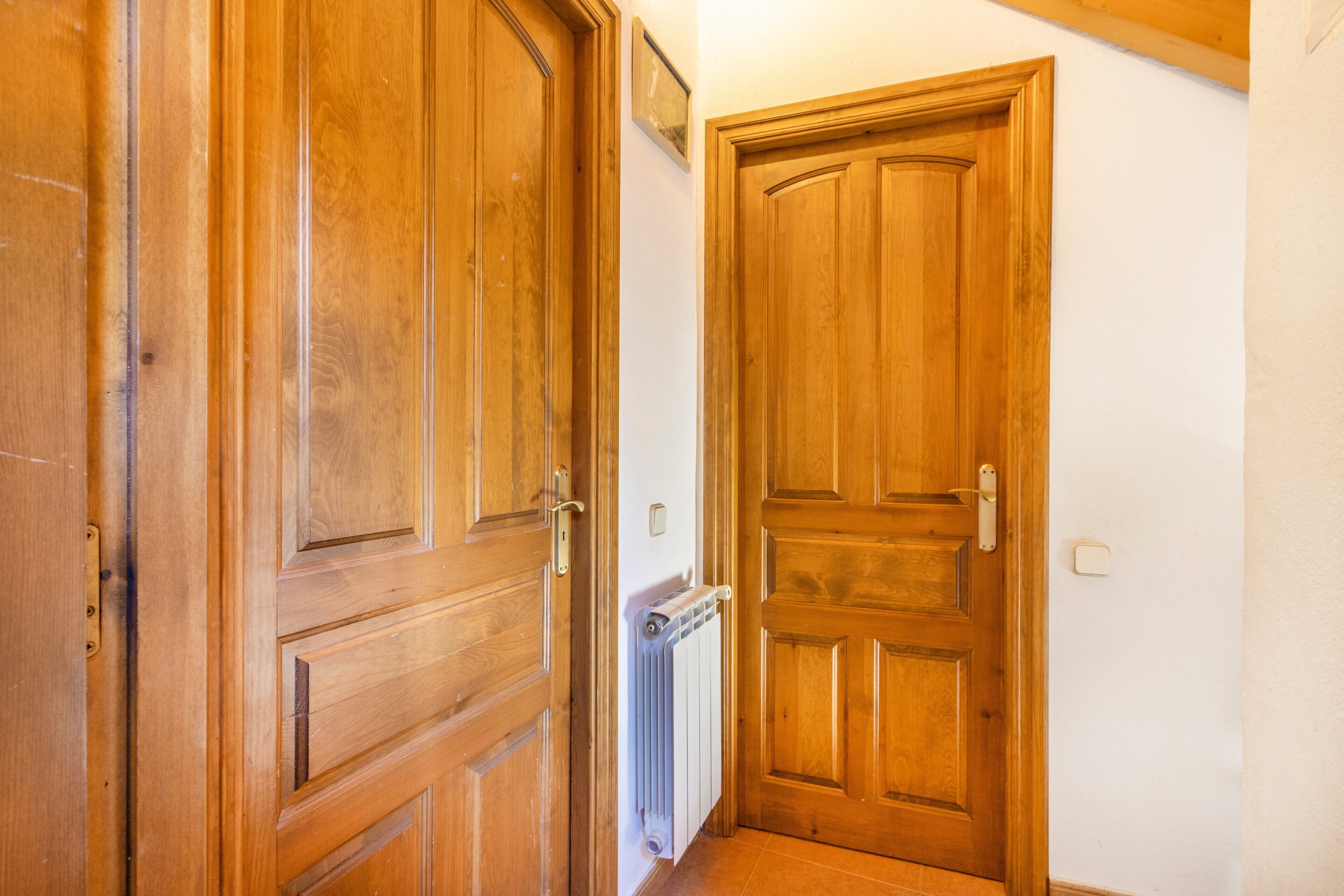 Una puerta de madera con un radiador y un interruptor de luz en la pared.