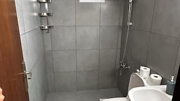 Chuveiro, toalhas de banho, sabonete, papel higiênico