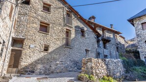 Ein Steinhaus mit einer Holztür, einer Treppe, die zu einem Balkon führt, und einem Schild mit der Aufschrift Museum.