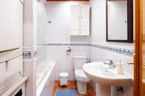 Une salle de bain avec des toilettes, un lavabo et un meuble de rangement.