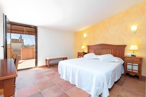 A bedroom with a bed, bedside tables, a bench, and a sliding door leading to a balcony. - Cottage 'Can Centena' with Private Pool, Wi-Fi and Air Conditioning (Vilamacolum)