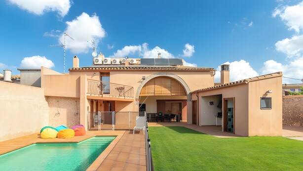 Une propriété résidentielle dotée d’une piscine, d’un patio couvert et d’une pelouse bien entretenue.