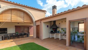 Une terrasse extérieure comprenant un espace repas, une cuisine et une salle de bain.