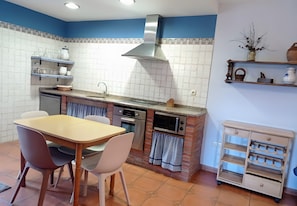 Uma cozinha com ilha central, forno embutido e micro-ondas.