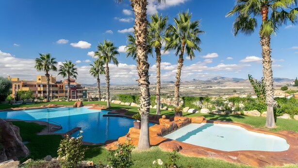 A pool area with palm trees, a clear sky, and distant mountains. - Apartment 'Appartement Avec 2 Piscines' with Sea View, Wi-Fi and Air Conditioning (Mutxamel)