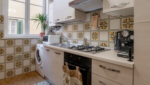 Une cuisine équipée d’un lave-linge, d’une cuisinière et d’une machine à café.