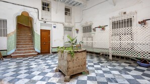 A checkered floor, a staircase, a wooden door, a white wall, and a white fence. - Apartment 'Ático San Jose' with Shared Terrace, Wi-Fi and Air Conditioning (Cádiz)