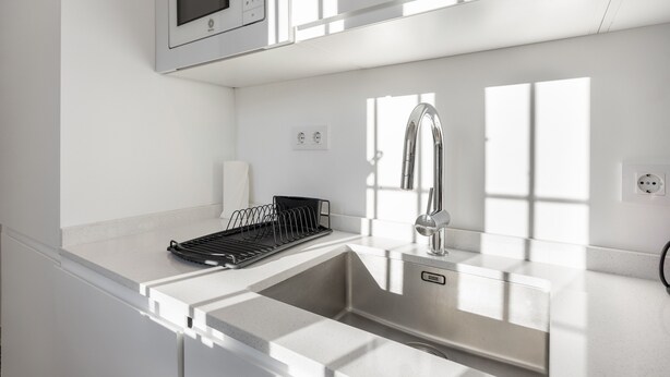 A modern kitchen with a stainless steel sink, a built-in microwave, and a power outlet. - Apartment 'Ático San Jose' with Shared Terrace, Wi-Fi and Air Conditioning (Cádiz)