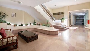 A spacious lobby with a curved seating area, a staircase, and a view into the hallway. - Sousa E Filhos Apartment – Shared Pool, Near the Beach (Albufeira)