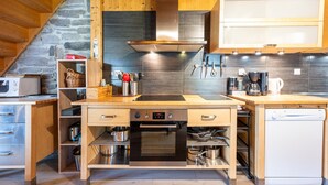 Eine kompakte Küche mit Backofen, Geschirrspüler und Holzschränken.