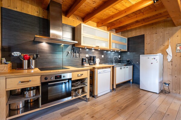 A modern kitchen with wooden cabinets, stainless steel appliances, and a wooden floor.