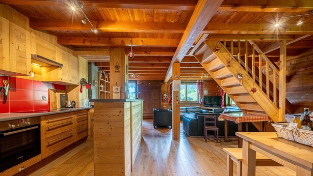 A wooden interior with a kitchen, dining area, and staircase. - Apartment "Le Chamois" with Shared Terrace, Balcony, and Wi-Fi (Flumet)