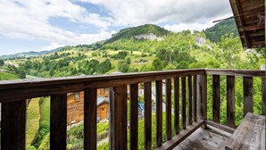 A wooden balcony with a view of a green valley and a mountain. - Apartment "Le Chamois" with Shared Terrace, Balcony, and Wi-Fi (Flumet)