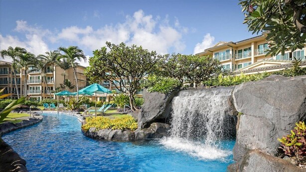 A hotel with a pool, a waterfall feature, and a building with balconies. - Waipouli Beach Resort A106 Oceanfront 2BD 3BA (Kapaʻa)