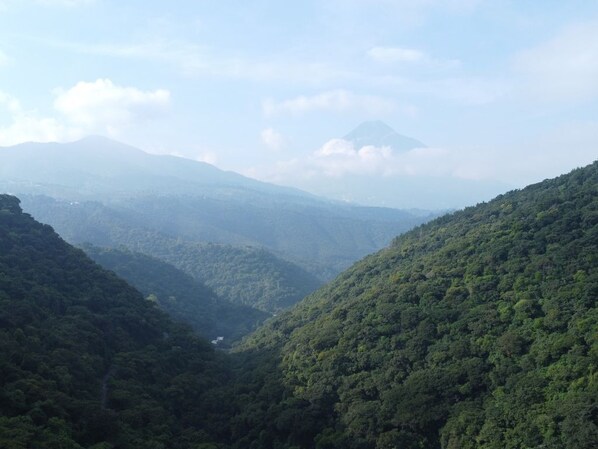 A mountainous landscape with dense forest coverage and a valley.