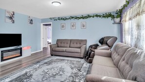A living room with a sofa, a TV, and a fireplace.