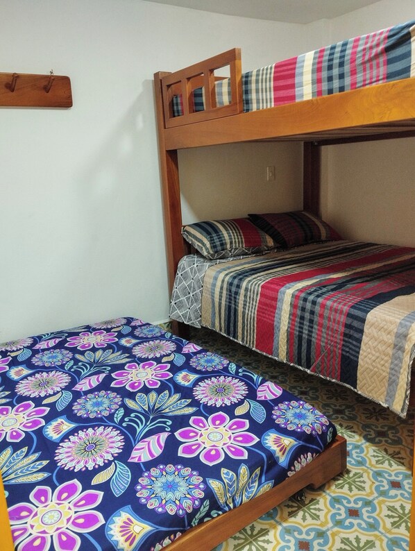 Una cama litera con una cama inferior y una superior, ambas con ropa de cama estampada.