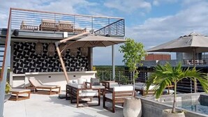 A rooftop terrace with outdoor seating, a pool, and a geometric wall design. - New, Modern Loft in Main Avenue Tulum (Tulum)