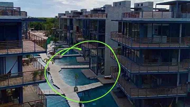 A modern hotel with multiple floors, a central pool area, and outdoor seating. - New, Modern Loft in Main Avenue Tulum (Tulum)