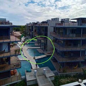 Ett modernt hotell med flera våningar, ett centralt poolområde och utomhusplats.