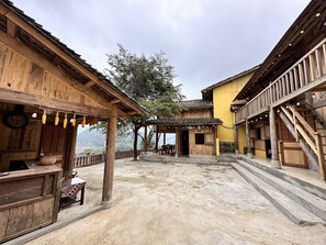 A rustic wooden building with a balcony and a staircase. - Hapu Homestay (Lung Cu)