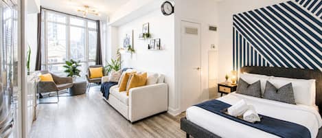 Un dormitorio moderno con una cama grande, un sofá y un comedor.