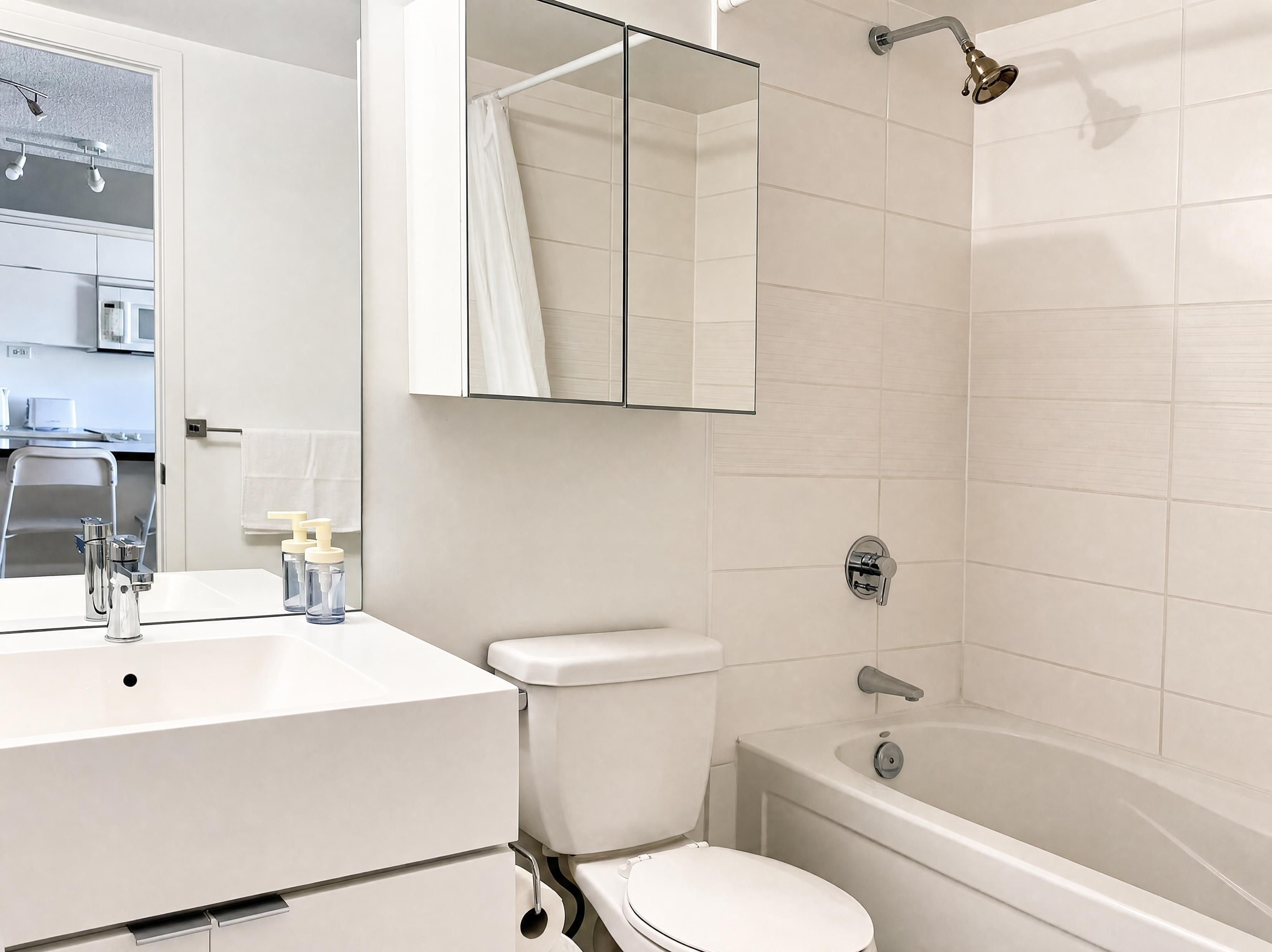 A modern bathroom with a white sink, toilet, and bathtub.