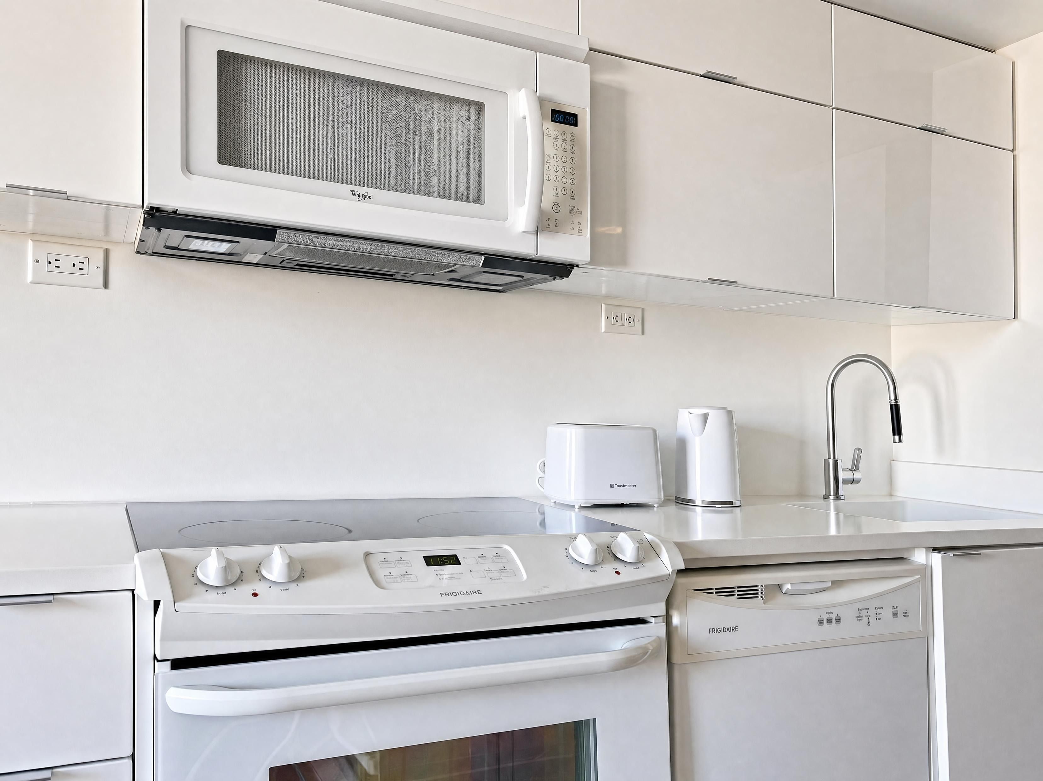 A modern kitchen with a built-in microwave, toaster, and dishwasher.