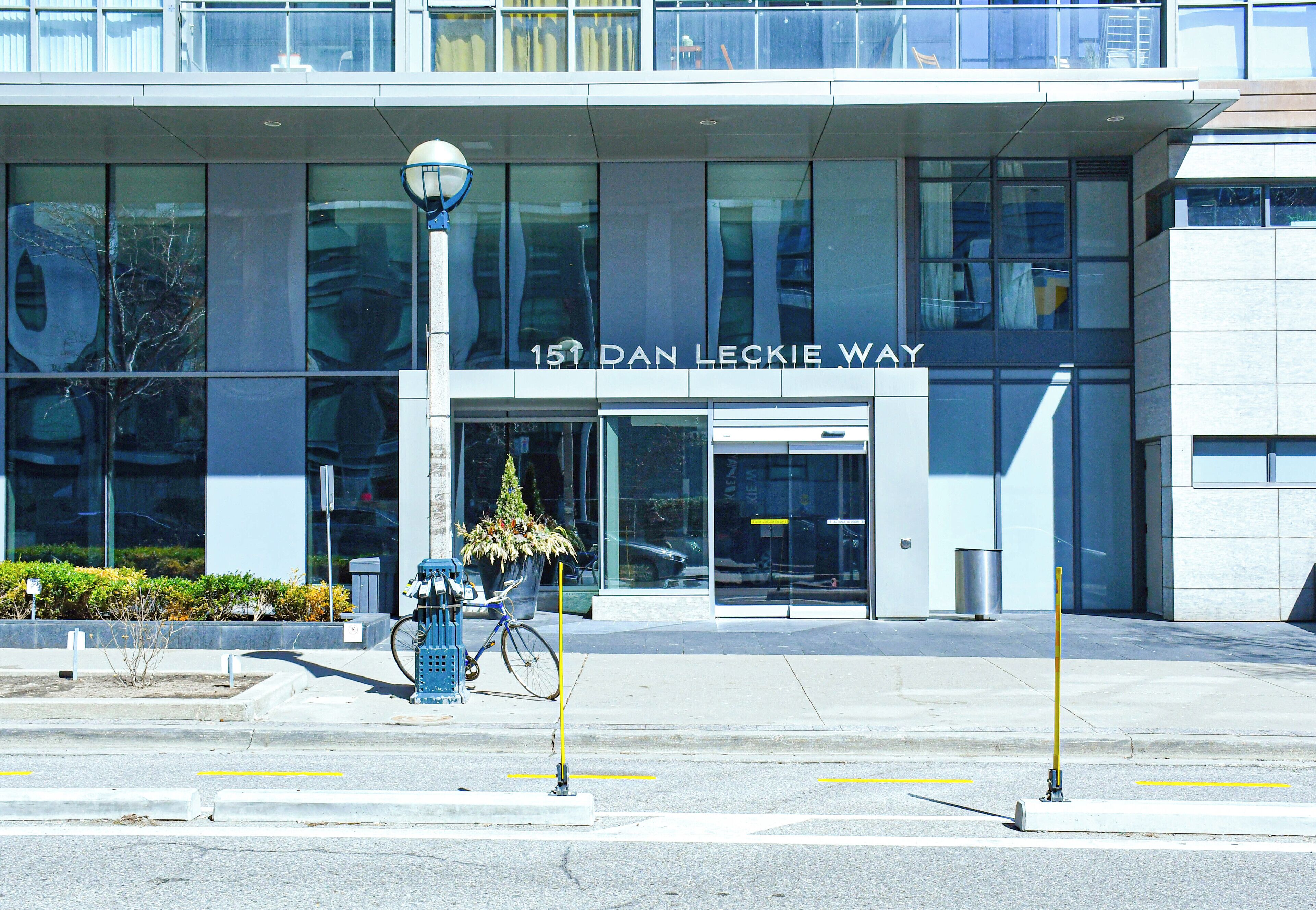 A modern building with a large glass facade and a sign reading "151 Dan Leckie Way".