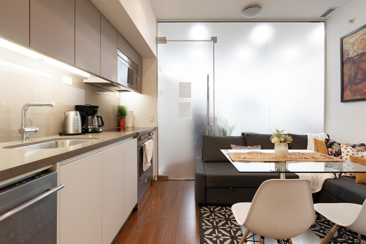 A modern kitchen with a built-in oven, a coffee maker, and a microwave.