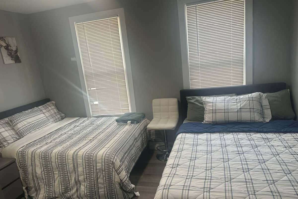 Une chambre avec deux lits, une chaise et une petite table.