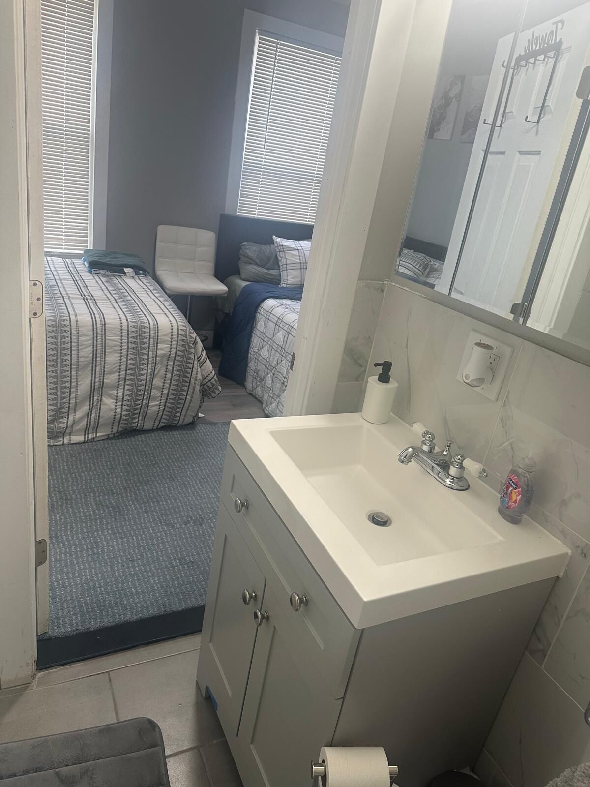 Ein gemütliches Schlafzimmer mit einem Bett, einem Sessel und einem kleinen Nachttisch.