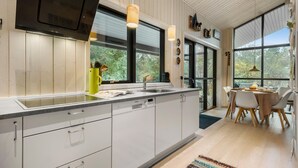 A modern kitchen with white cabinets, a built-in oven, and a large window. - Stunning home in Asnæs with WiFi (Asnæs)