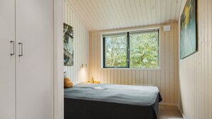 A bedroom with a bed, a window, and wooden walls. - Stunning home in Asnæs with WiFi (Asnæs)