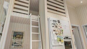 A kitchen with a white refrigerator adorned with various magnets and notes, a white ladder leaning against the wall, and a painting on the lower wall. - Stunning home in Asnæs with WiFi (Asnæs)