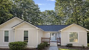A single-story house with a front porch, a small front yard, and a pathway leading to the entrance. - Spacious 2-bedroom, 1 bathroom Basement Apartment near Braves Stadium (Marietta)