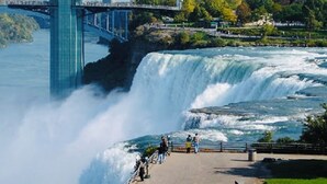 A waterfall with a bridge in the background.