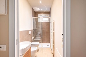 Une salle de bain moderne équipée d’une douche, de toilettes et d’un lavabo.