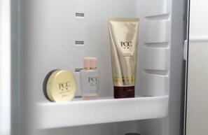 Ein Kühlschrank mit einer Ablage, auf der sich ein Tiegel mit PCCA Hautpflegeprodukt, ein kleiner Behälter und eine Flasche befinden.
