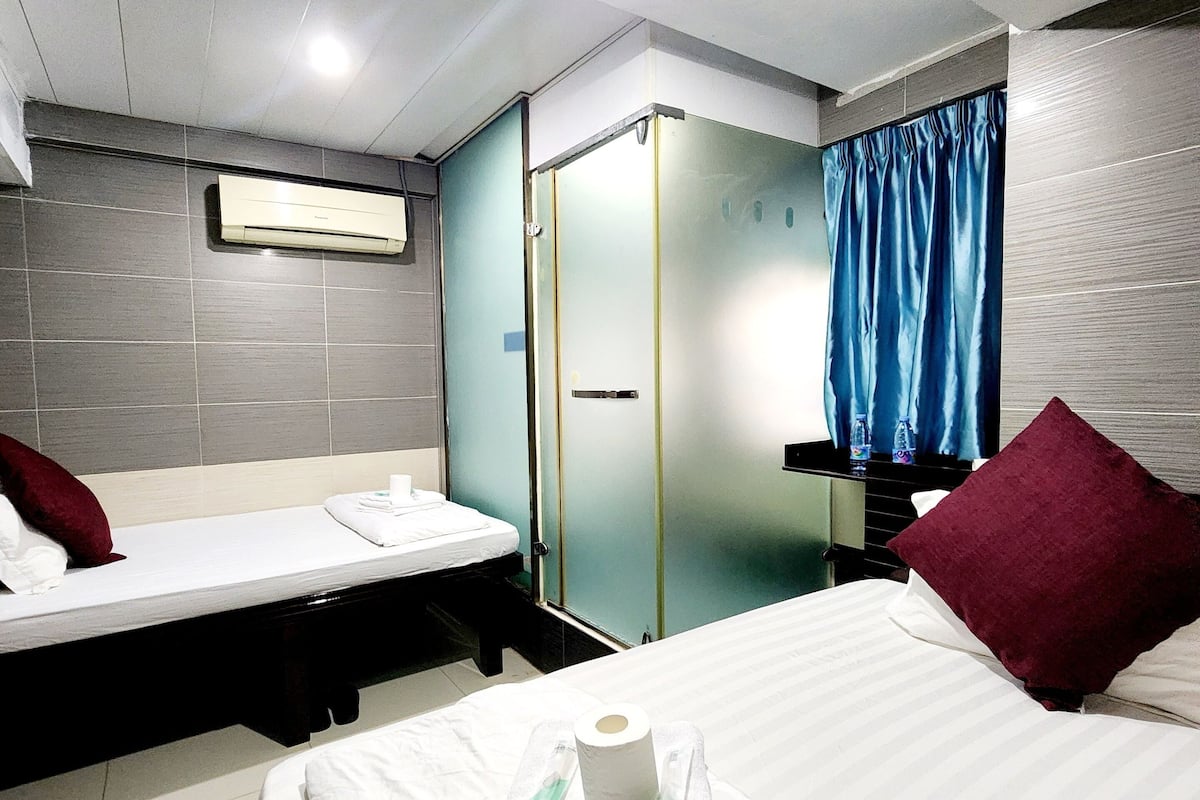 Une chambre d’hôtel comprenant un lit, un petit lit, une salle de bain et une armoire.